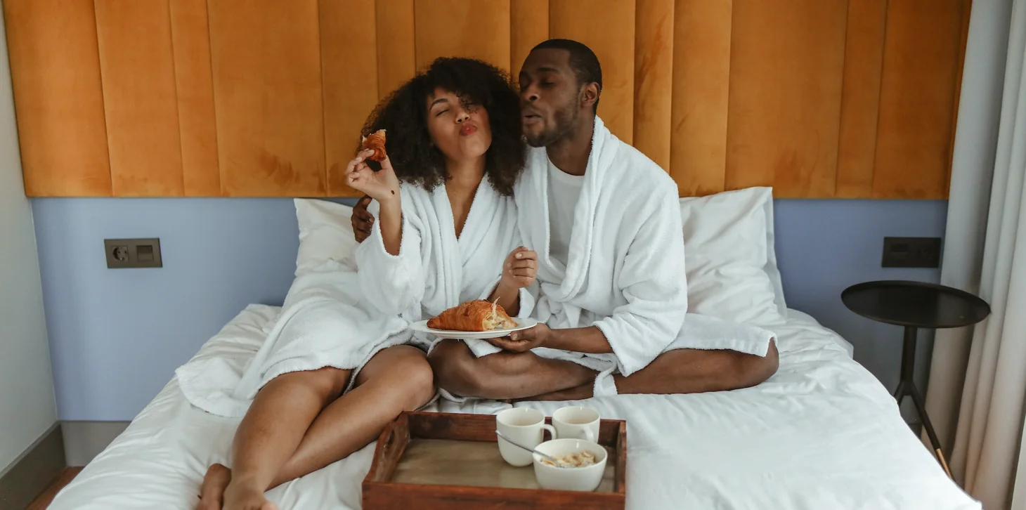 A couple eating breakfast in bed