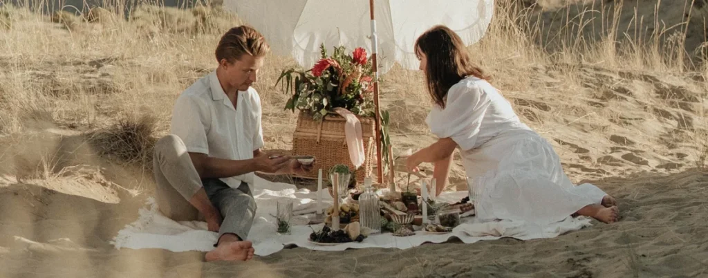 A couple having a picnic date on a beach